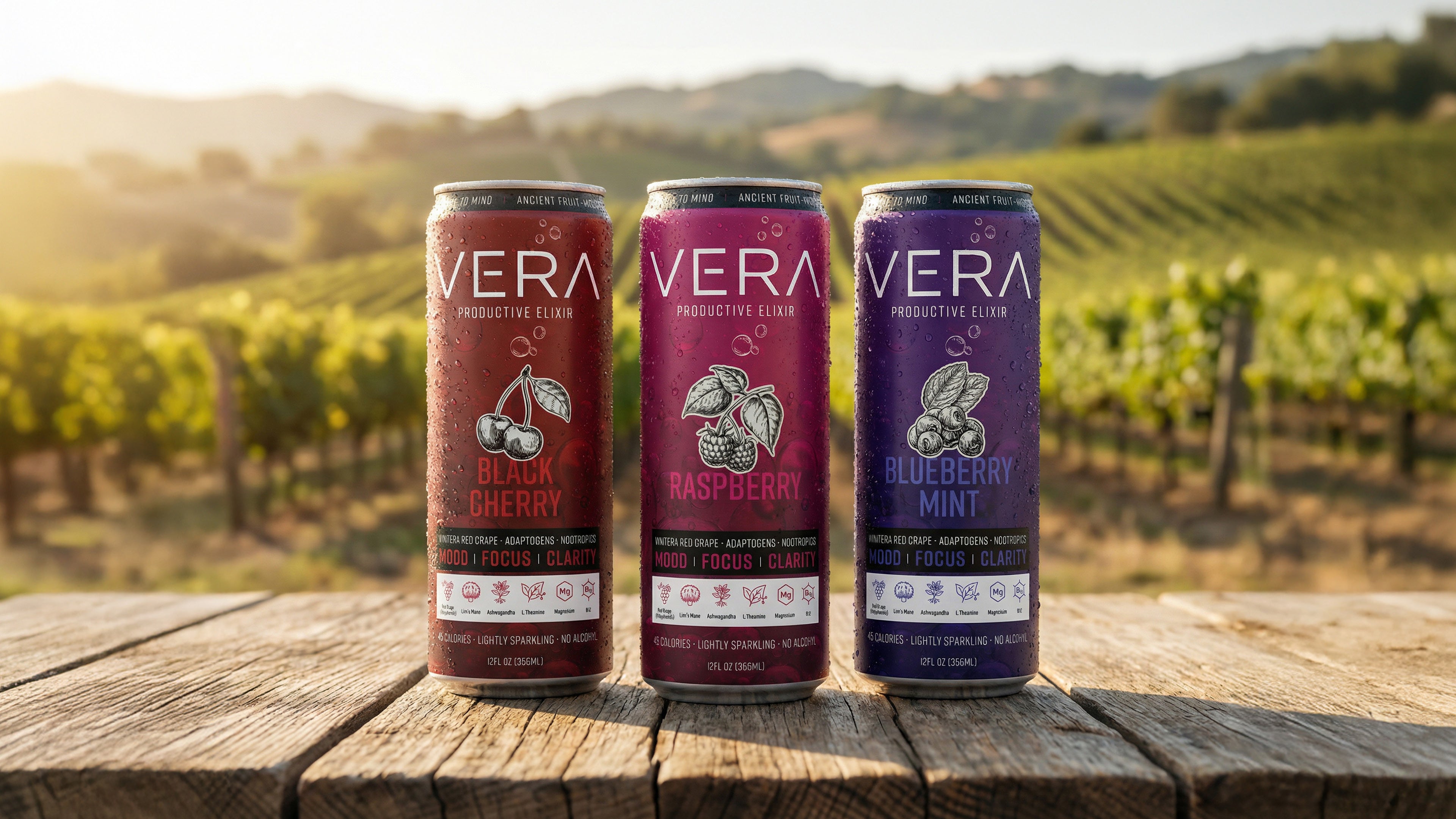 Three cans of Vera Productive Elixir in Black Cherry, Raspberry, and Blueberry Mint flavors standing on a rustic wooden table with a sunlit vineyard in the background.